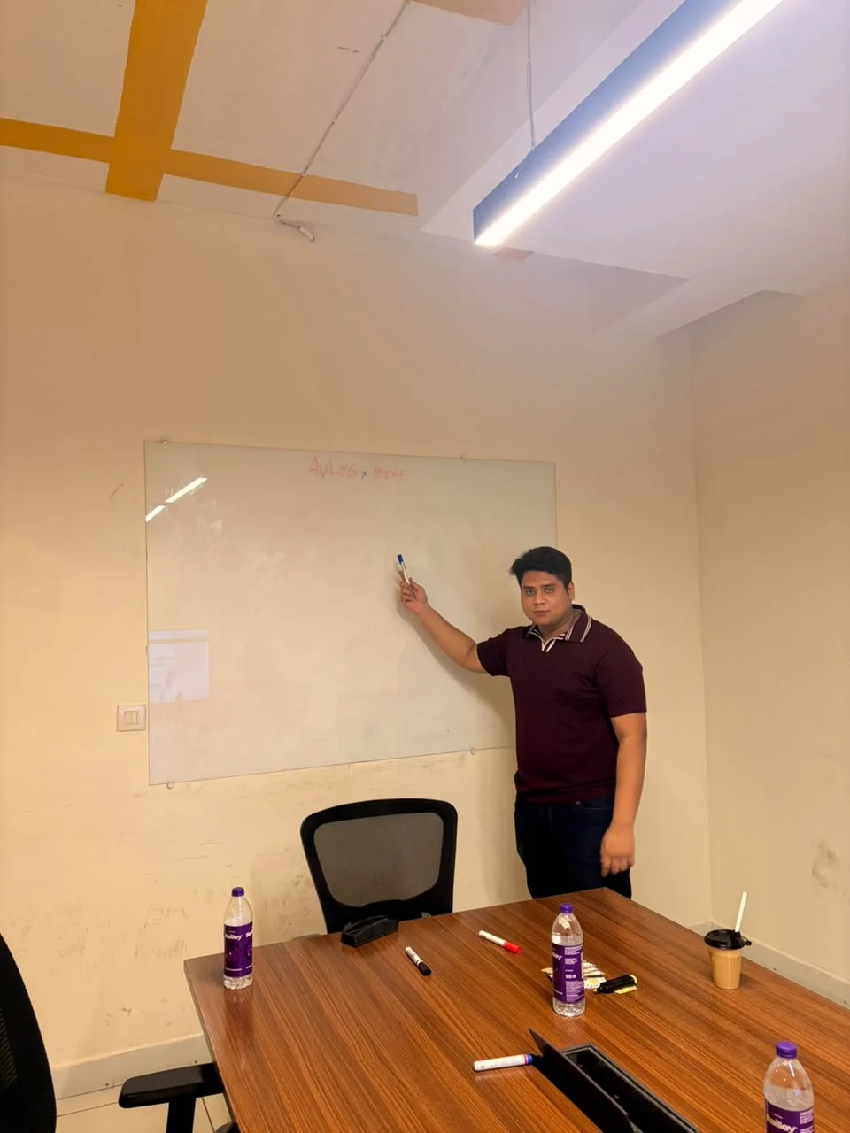 An Avlys team member at the office whiteboard during a planning session.