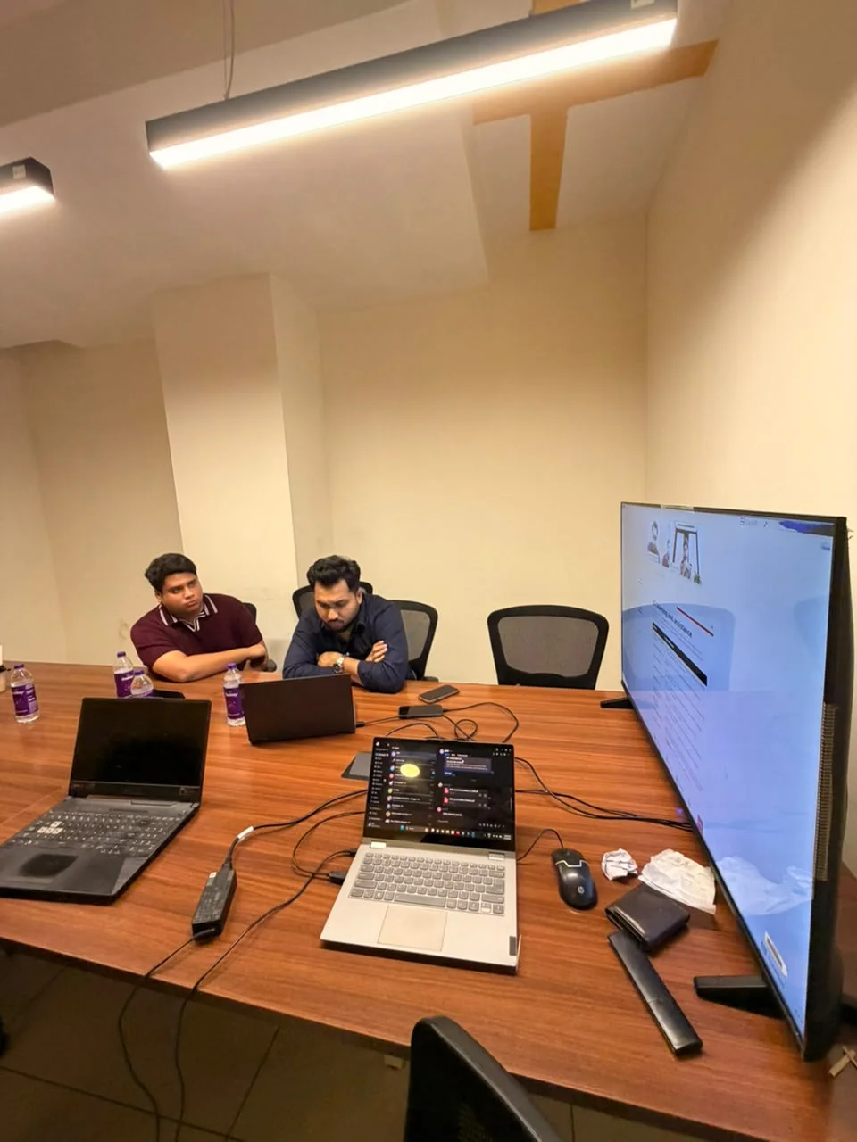 Two Avlys team members working at laptops in the meeting room.